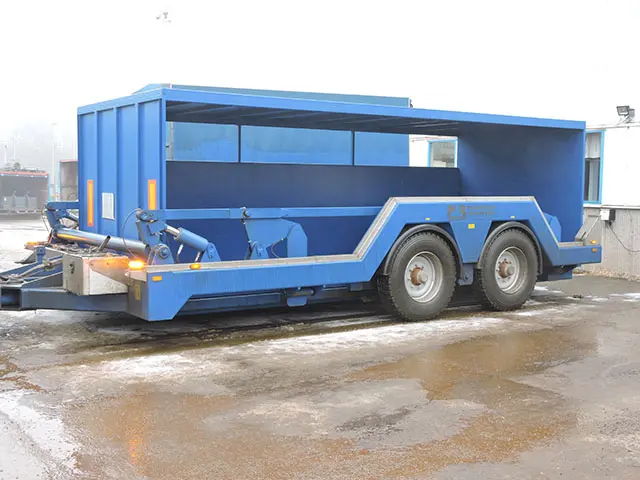 Bygelvagn med container som är öppen från sidan